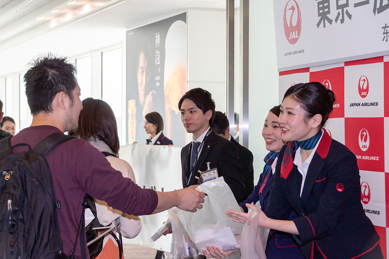 乗客にはポストカードやボールペン、メモ帳などが入った記念品が手渡され、植木会長も並んで乗客を見送った