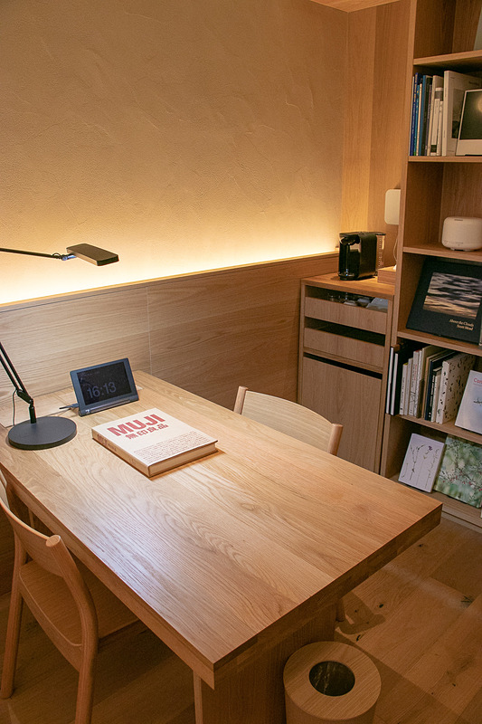 デスクまわり。背面の本棚にはMUJI BOOKSの書籍