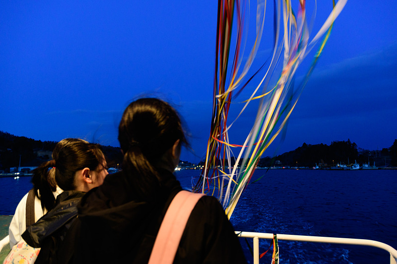 離れていく大島を見る乗客