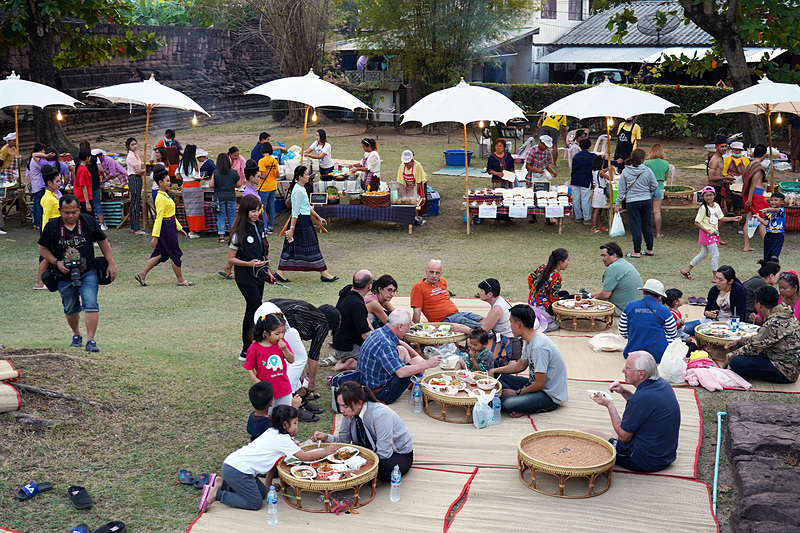 ゴザの上でお祭りの食事を食べる人たち。みんな楽しそう