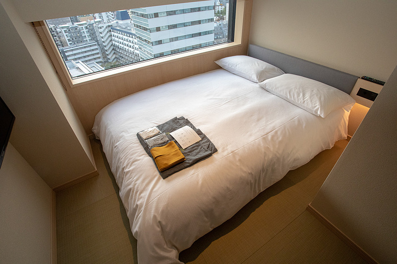 セミダブルルーム。雪見窓からイメージした窓が特徴的。この写真ではベッドで部屋がいっぱいに見えるがそんなことはない