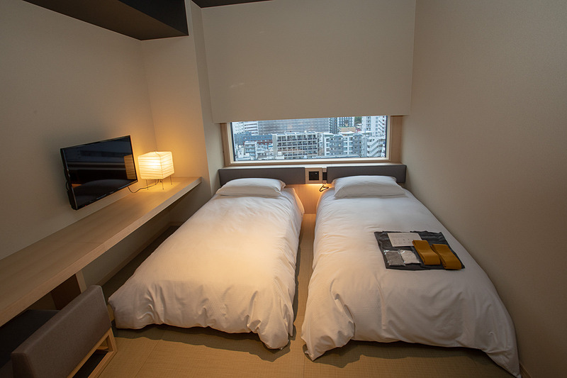 客室を囲うようにしつらえたテーブルがベッドサイドまで伸びている。ベッドに腰掛けながらのPC作業なども可能