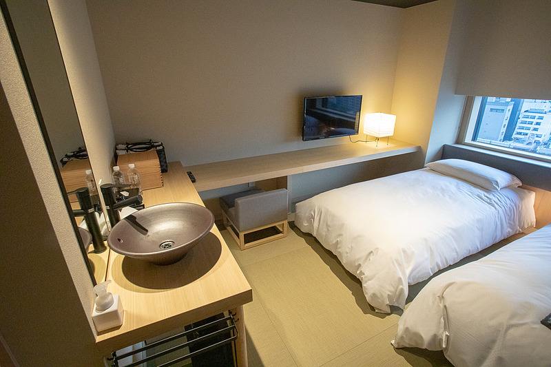 部屋を囲うように配置されたテーブル。洗面台がベッドルームにあるというユニークな作り