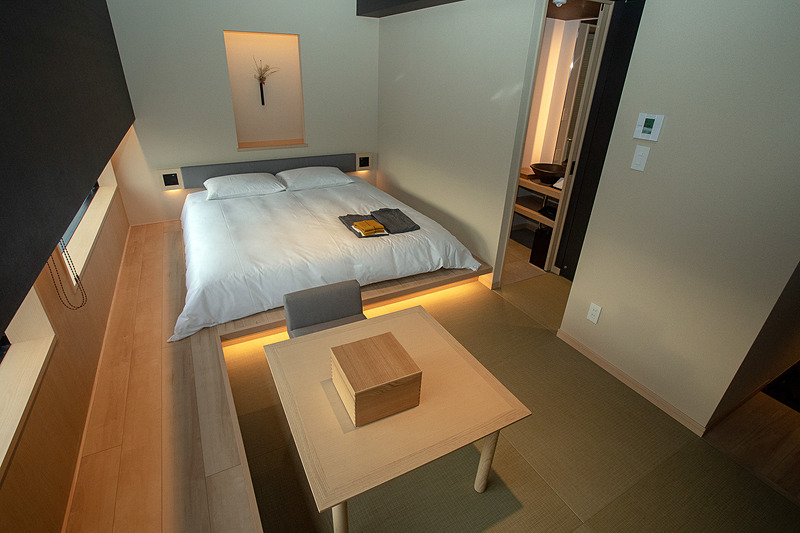 3階～17階にあるダブルルーム。25m<sup>2</sup>の広さは「ONSEN RYOKAN 由縁 新宿」独自の廊下がない作りでより活かされる。窓際には腰掛けたりモノを置いたりするのにも使える板の間を設置。雪見窓イメージの窓は立った状態と座った状態で見える景色が異なる