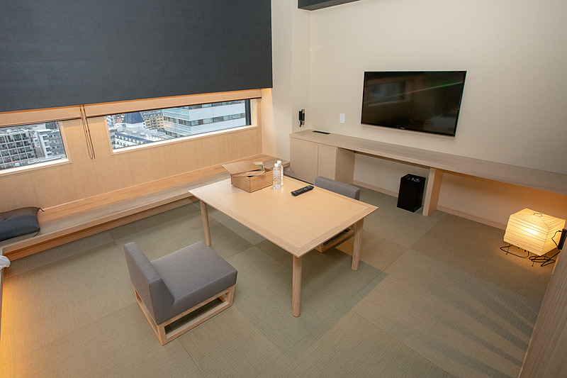 ベッドの反対側にはイストテーブル。そしてテレビがある。テレビ下はPC作業に適した高さのテーブルになっているのでイスをこちらに持ってくると仕事も可能