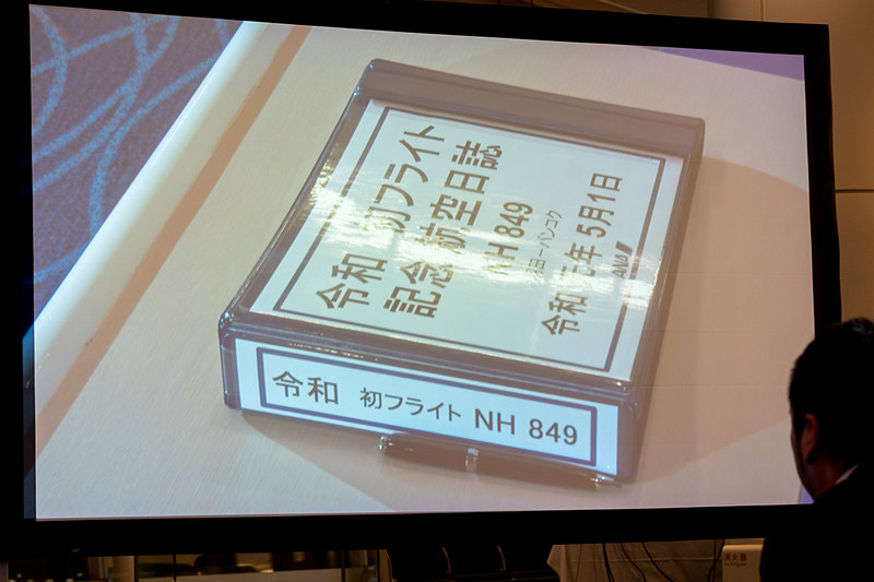 代表取締役社長の平子裕志氏が安全の思いを記した航空日誌を、NH849便を担当した平成元年生まれの整備士である増田一輝さん、NH849便の清水智 機長に引き継いだ