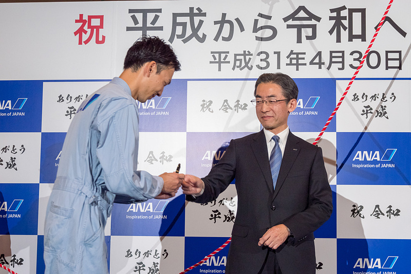 代表取締役社長の平子裕志氏が安全の思いを記した航空日誌を、NH849便を担当した平成元年生まれの整備士である増田一輝さん、NH849便の清水智 機長に引き継いだ