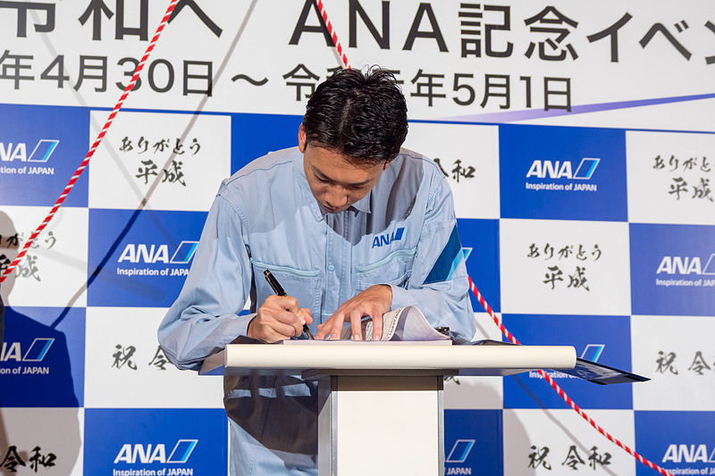 代表取締役社長の平子裕志氏が安全の思いを記した航空日誌を、NH849便を担当した平成元年生まれの整備士である増田一輝さん、NH849便の清水智 機長に引き継いだ