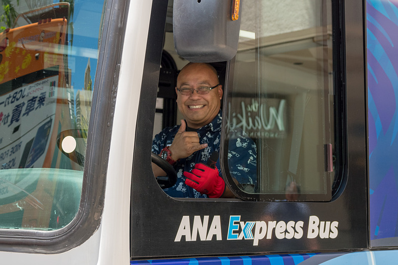 青いANAエクスプレスバス。モンステラなどハワイをイメージしたリーフを背景に親子のウミガメが泳ぐデザイン