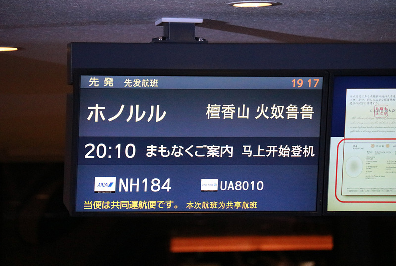 搭乗者をゲートで迎え一礼する平子社長と石田成田空港支店長。ディスプレイにはラニの画像も表示。フライト時間は7時間20分、現地は曇り、気温は23℃（摂氏）と表示されていた