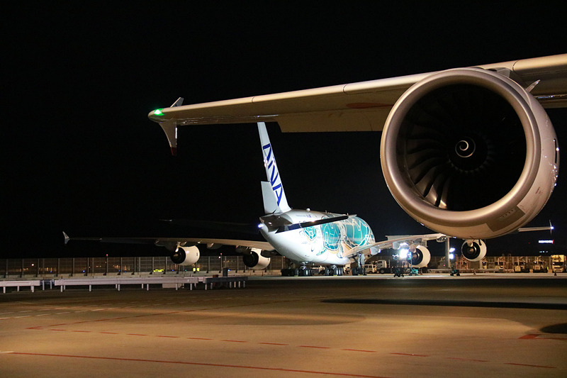 ラニのエンジンの向こうに見えるのは、FLYING HONU 2号機のカイ。機長が地上の見送りに向かい手を振ってプッシュバック。トーイングカーにもメッセージが貼られていた