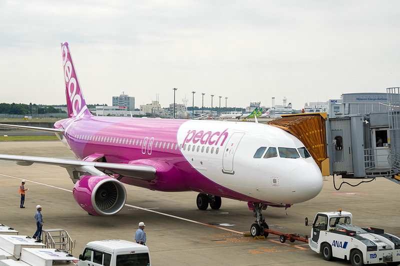 井上CEOやCAらが出発機を見送り。偶然、その後方をバニラエア機が通過するシーンも