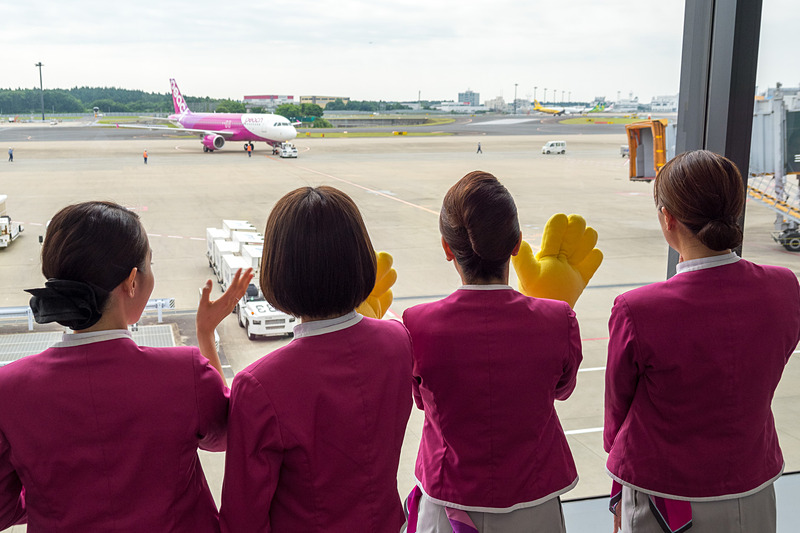 井上CEOやCAらが出発機を見送り。偶然、その後方をバニラエア機が通過するシーンも