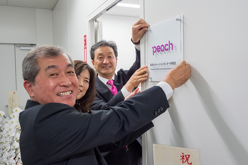 プレートを受け取り、準備室の入り口に設置したPeach Aviation株式会社 成田オペレーションセンター準備室 室長 富永有一氏