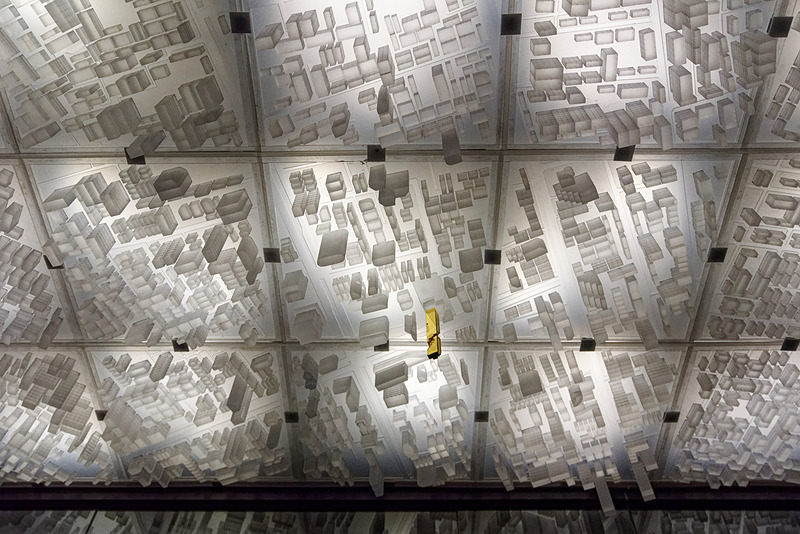 エレベータホールに向かう廊下。天井にはバンコク市街のジオラマが。ゴールドのビルがキングパワー・マハナコーンビルだ