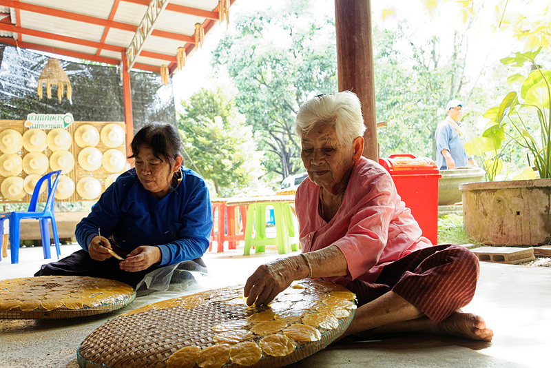 マンゴーのお菓子作りに精を出す、農園のオーナーであるトンイップさん（右）