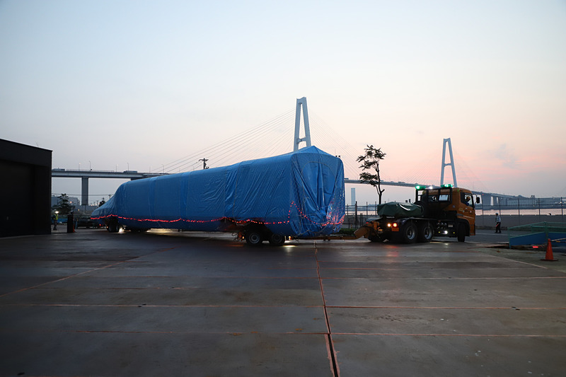 トレーラーが大きく切り返し、慎重に展示スペース付近まで進む