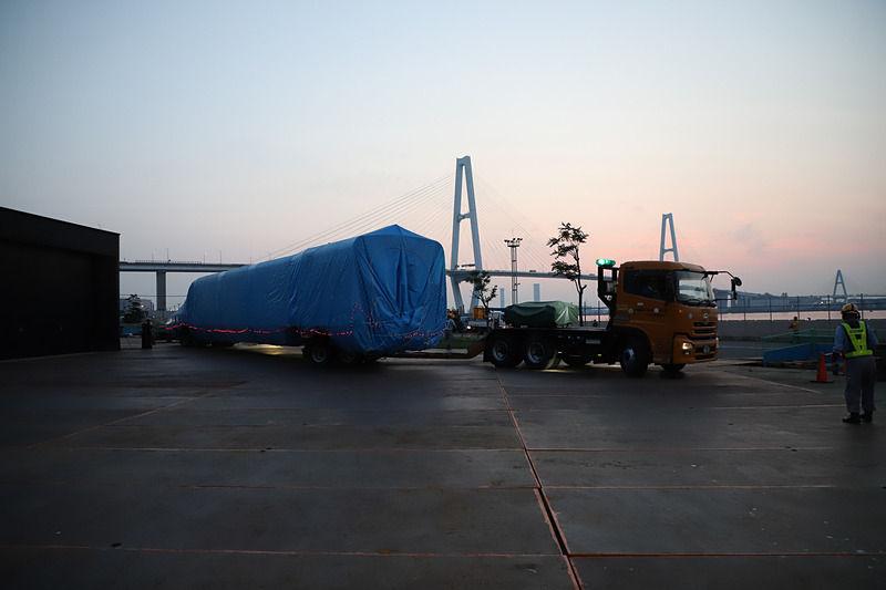 トレーラーが大きく切り返し、慎重に展示スペース付近まで進む