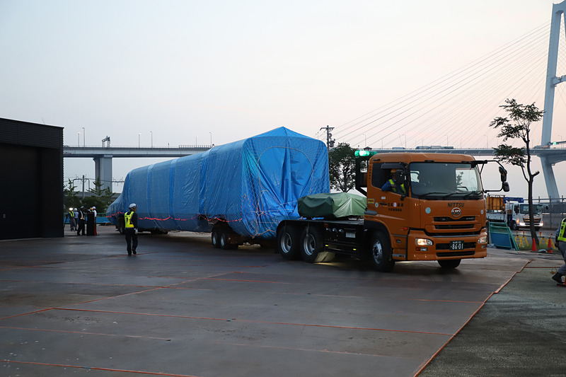 トレーラーが大きく切り返し、慎重に展示スペース付近まで進む