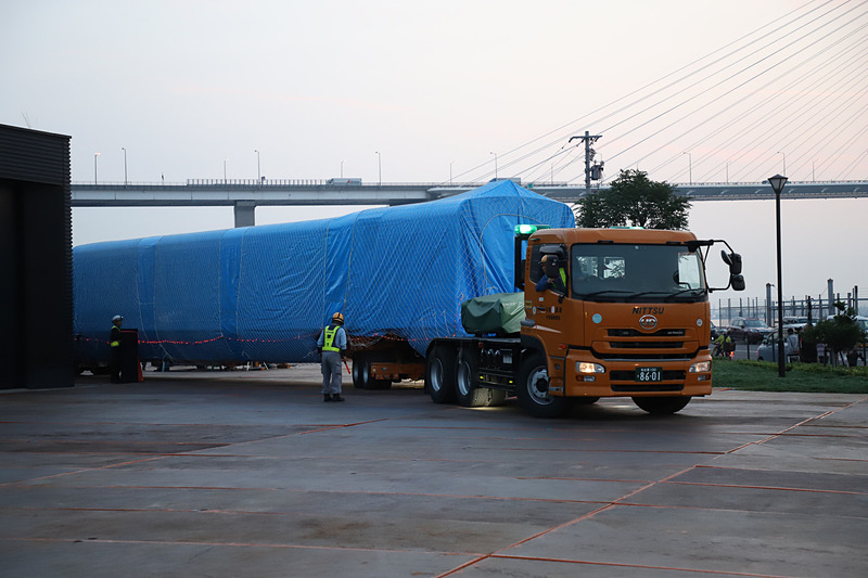 トレーラーが大きく切り返し、慎重に展示スペース付近まで進む