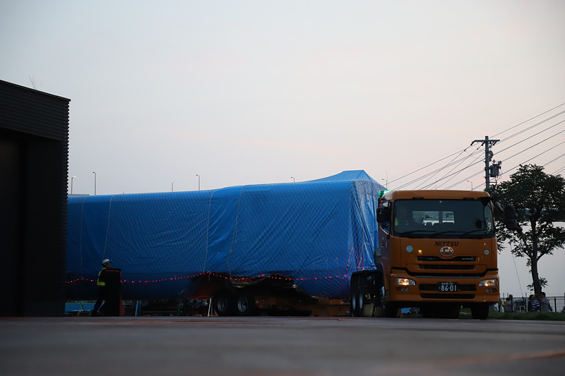 トレーラーが大きく切り返し、慎重に展示スペース付近まで進む