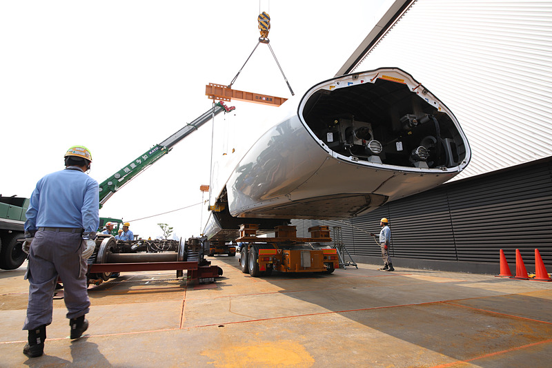 トレーラーの台車を移動させるため、新幹線車両を吊り上げる