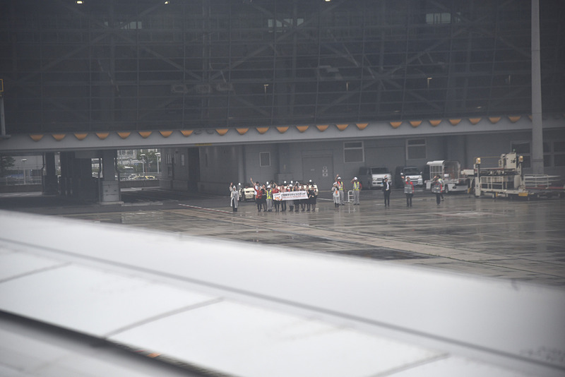 駐機場ではお見送りイベントを実施。雨のなか横断幕を掲げ「ご搭乗ありがとうございます」の文字が遠くに見えた