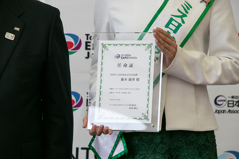 田川会長から藤本麗華さんへ任命証が渡される