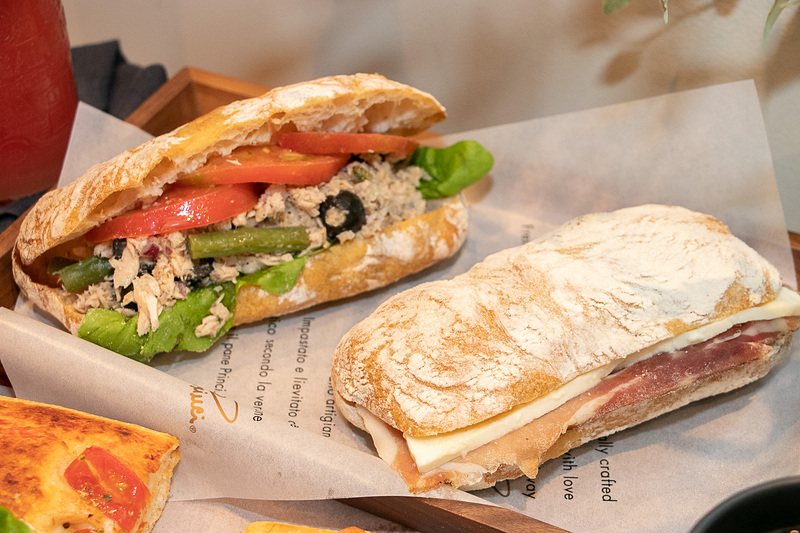 左は、たっぷりのツナにフレッシュトマトとブラックオリーブを合わせ、レモンとケッパーの心地よい酸味がさわやかな「チャバッタ サンドイッチ ツナ ＆ レモン ケッパー」（740円、税別）。右は、燻製し熟成させたイタリア産のスペックハムとモッツァレラをはさんだ「チャバッタ サンドイッチ スペック ＆ モッツァレラ」（760円、税別）