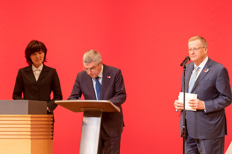 招待状にサインをするバッハ会長