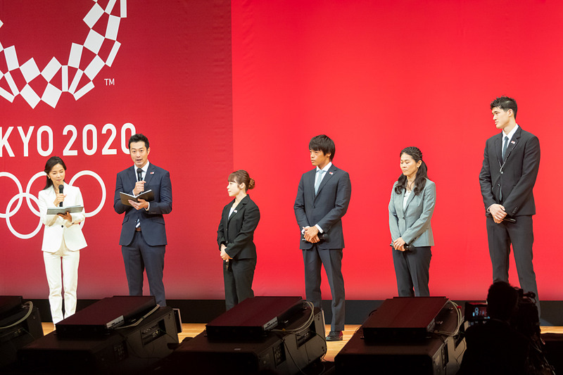 メダルデザインの発表に立ち会う三宅宏実さん、羽根田卓也さん、澤穂希さん、渡邊雄太さん。司会進行を務めるのは元NHKアナウンサーの久保純子さんと元競泳選手で北京2008大会 銅メダリストの宮下純一さん