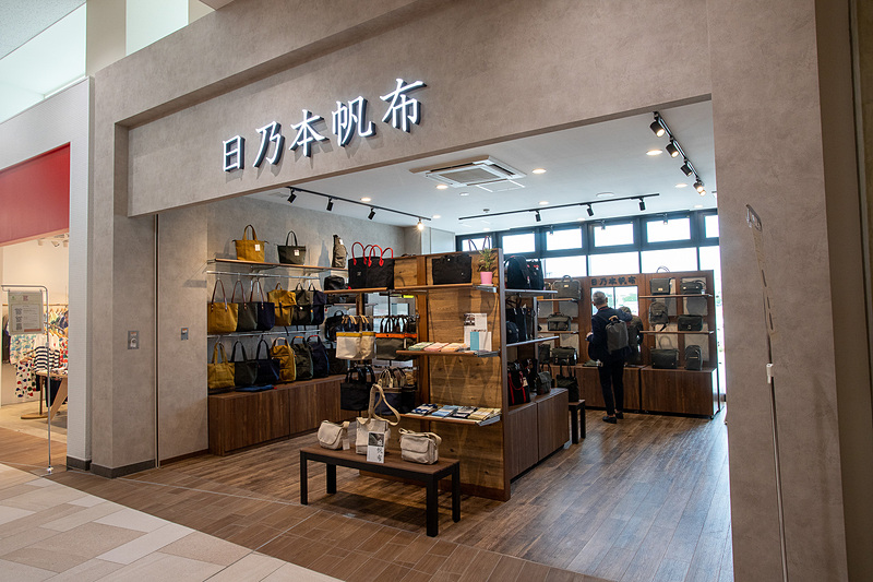 日本の伝統的な帆布を使用し、米沢にある工房で一点ずつ職人の手作業で作られているカバンや小物の「日乃本帆布（ひのもとはんぷ）」。写真の手提げは試作車などのカモフラージュに使われる模様をあしらったものという。営業時間は9時～21時。高速道路初出店