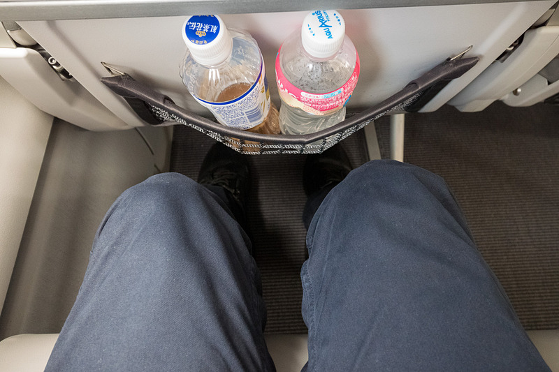 これはシートピッチ30インチ（約76.2mm）の座席だが、薄いシートを採用していることで、足下のシートポケットに500mL前後のペットボトルを2本入れても多少ゆとりがある。ただ、シートテーブルを広げてのノートPC（写真は12.5型液晶搭載機）の使用にはやや窮屈