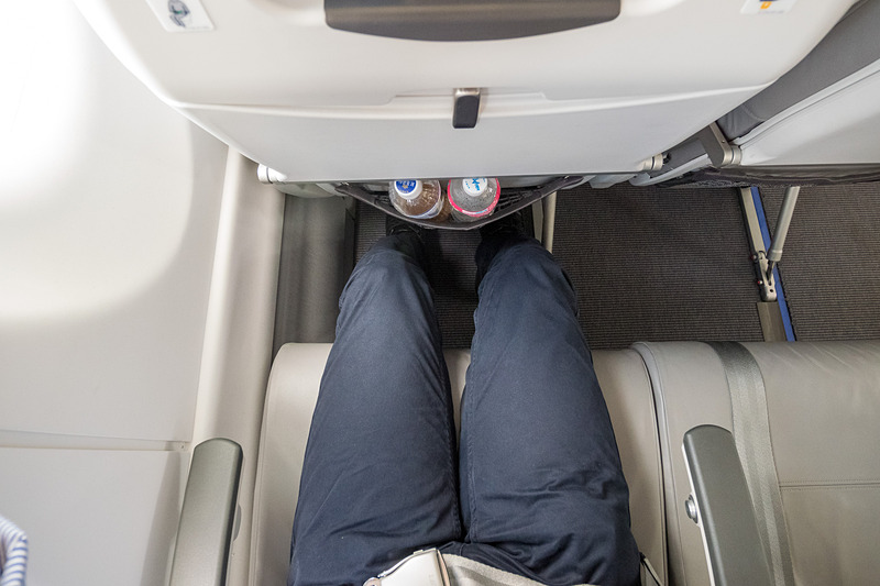 これはシートピッチ30インチ（約76.2mm）の座席だが、薄いシートを採用していることで、足下のシートポケットに500mL前後のペットボトルを2本入れても多少ゆとりがある。ただ、シートテーブルを広げてのノートPC（写真は12.5型液晶搭載機）の使用にはやや窮屈
