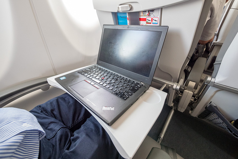 これはシートピッチ30インチ（約76.2mm）の座席だが、薄いシートを採用していることで、足下のシートポケットに500mL前後のペットボトルを2本入れても多少ゆとりがある。ただ、シートテーブルを広げてのノートPC（写真は12.5型液晶搭載機）の使用にはやや窮屈