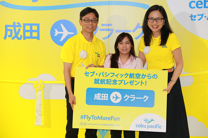5J5069便の搭乗手続き1番の搭乗者を表彰して、セブ・パシフィック航空のイヨグ氏と松本氏から「またセブ・パシフィック航空に乗ってクラークに行ってほしいから」と航空券をプレゼント