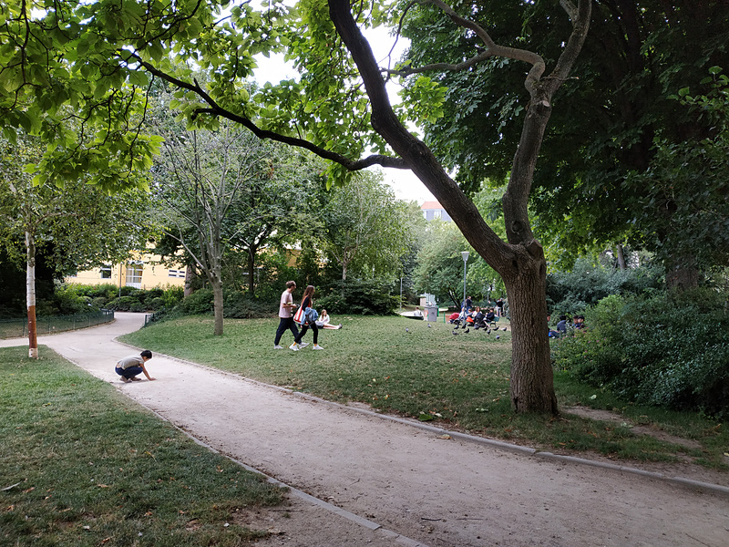 24時間、夜間も公園を解放していますよという案内と公園で涼む人々