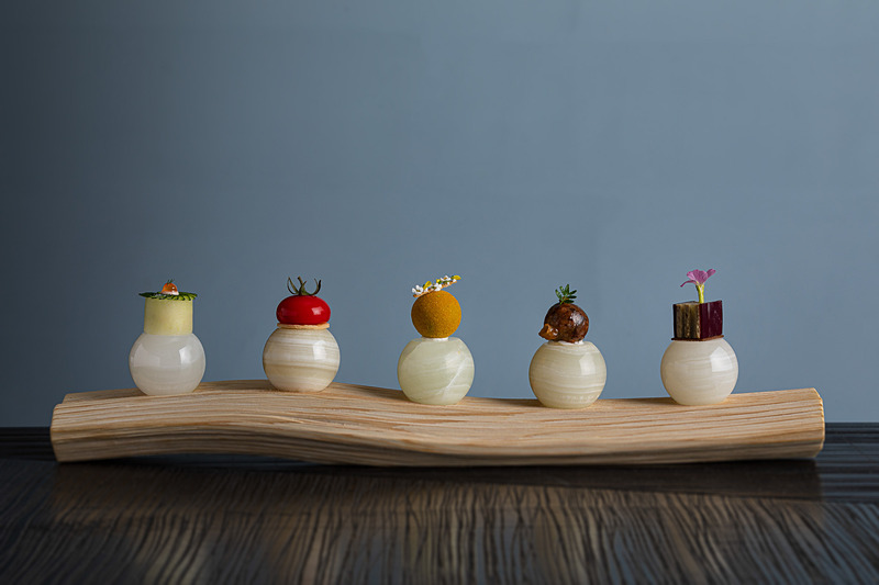 五味「酸・旨・苦・辛・甘」を一口サイズの料理で表現した「Nipponキュイジーヌ 五つの意思」。下の石は料理にあわせて温度を変えているそう（写真提供：星野リゾート）