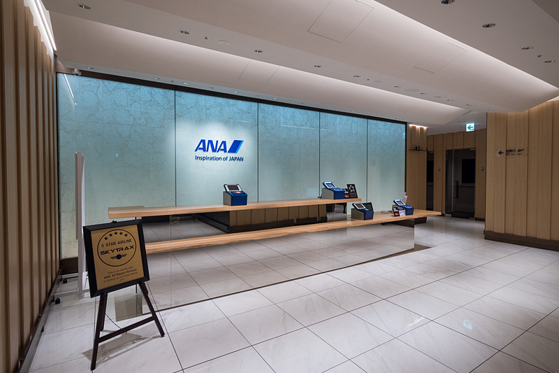 ANA SUITE LOUNGE/ANA LOUNGEのエントランス。受付の右側にANA SUITE LOUNGE、左側にANA LOUNGEがある。受付右手奥の搭乗口へ向かう動線上に通話エリアや喫煙所があり、これもANA SUITE LOUNGE/ANA LOUNGE共用となる