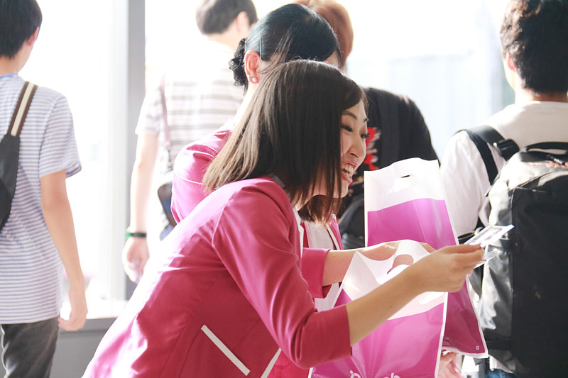 黄色いビッグハンドによるハイタッチと記念フライトタグの配布の模様