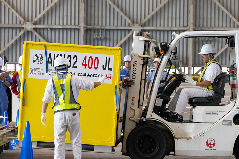 フォークリフトの搭降載では、オペレーターと確認作業員が息を合わせながら進めていく