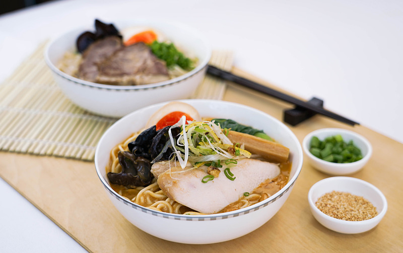 ビジネスクラスで提供する「けいすけロブスターラーメン」（手前）と「けいすけ豚骨ラーメン」（奥）