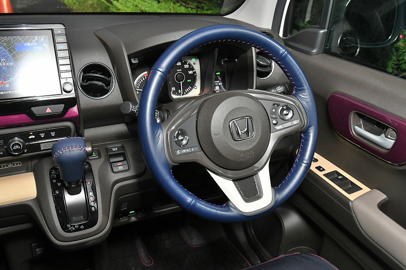 ステアリングホイールカバーはネイビーの革巻きタイプで、ステッチはボルドーピンクとなっている。手触りもよく、上質さが伝わってくる。価格は9000円（税別）。シフトノブも本革製。カラーもネイビー×ボルドーピンク。価格は7500円（税別）