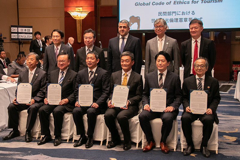 「UNWTO(国連世界観光機関)世界観光倫理憲章署名式」が行なわれた。前列左から、株式会社湯元舘 代表取締役会長 針谷了氏、鶴雅ホールディングス株式会社 代表取締役 大西雅之氏、株式会社滝の湯ホテル 代表取締役社長 山口敦史氏、株式会社ピッキオ 取締役 楠部真也氏、株式会社西村屋 代表取締役社長 西村総一郎氏、一般社団法人日本旅館協会 会長 北原茂樹氏。後列左から、アジア太平洋観光交流センター 会長 尾崎裕氏、観光庁 長官 田端浩氏、国連世界観光機関 事務局長 ズラブ・ポロリカシュヴィリ氏、国連世界観光機関 駐日事務所 代表 本保芳明氏、国連世界観光機関 アジア太平洋部 部長 ス・ジン氏