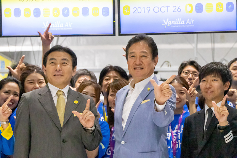 カウンター前でVマークで記念撮影。中央は代表取締役社長の井上慎一氏、左は取締役副社長の森健明氏