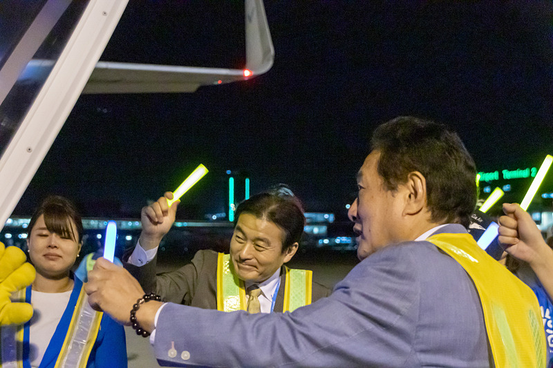 バニラ・エア株式会社 代表取締役社長の井上慎一氏（右）と取締役副社長の森健明氏（中央）もタラップ脇で利用客にあいさつ