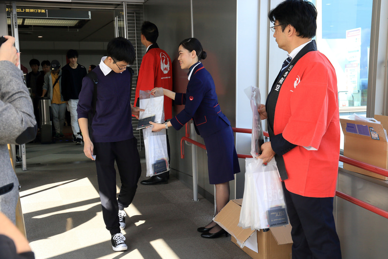 記念品を受け取りA350に乗り込む搭乗客