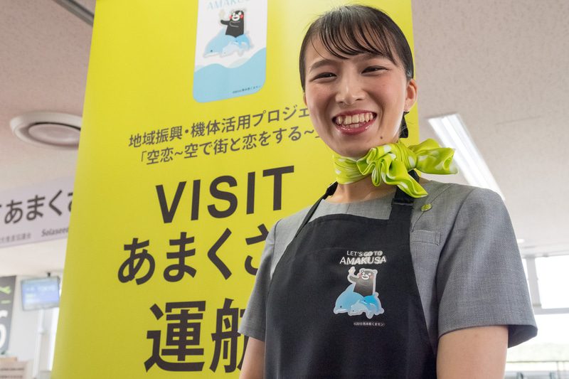 CA（客室乗務員）は「イルカに乗ったくまモン」デザインのエプロンを機内で着用する