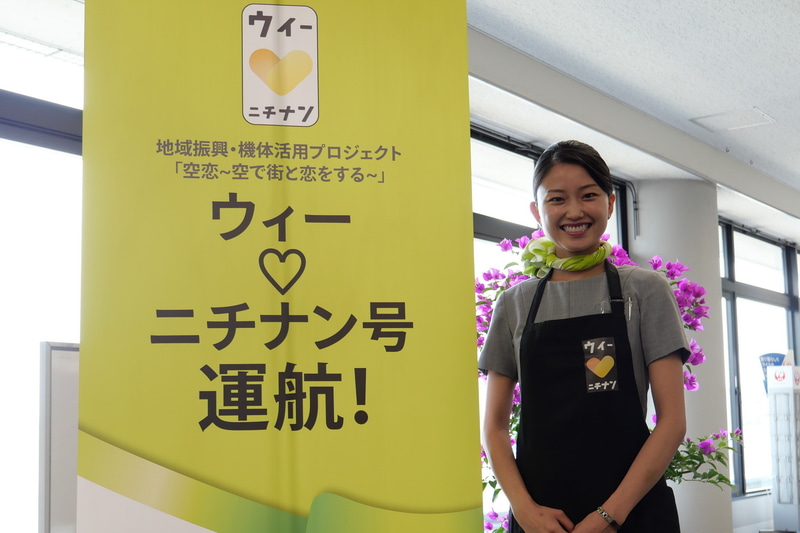 CAは、「ウィーラブニチナン」のロゴの入ったエプロンを機内で着用する