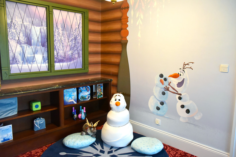結晶が描かれたふんわりマットの上にはオラフ。絵本やおもちゃが揃ったプレイコーナー